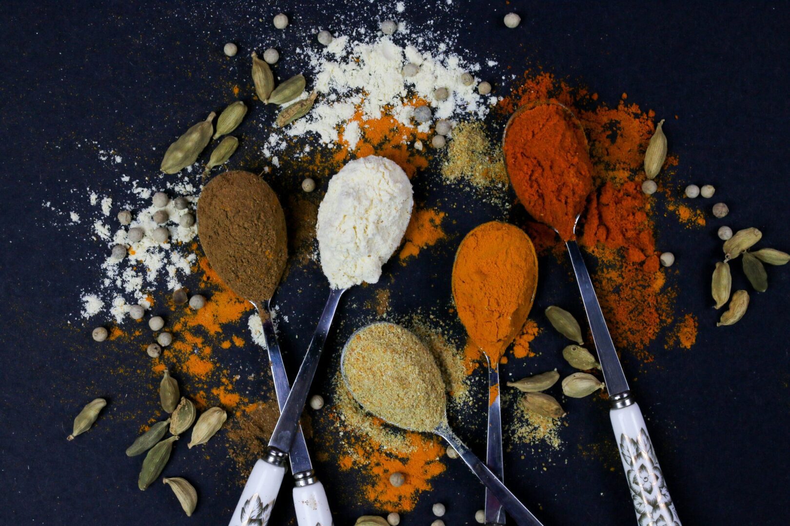 A spoonful of spices on a black background.