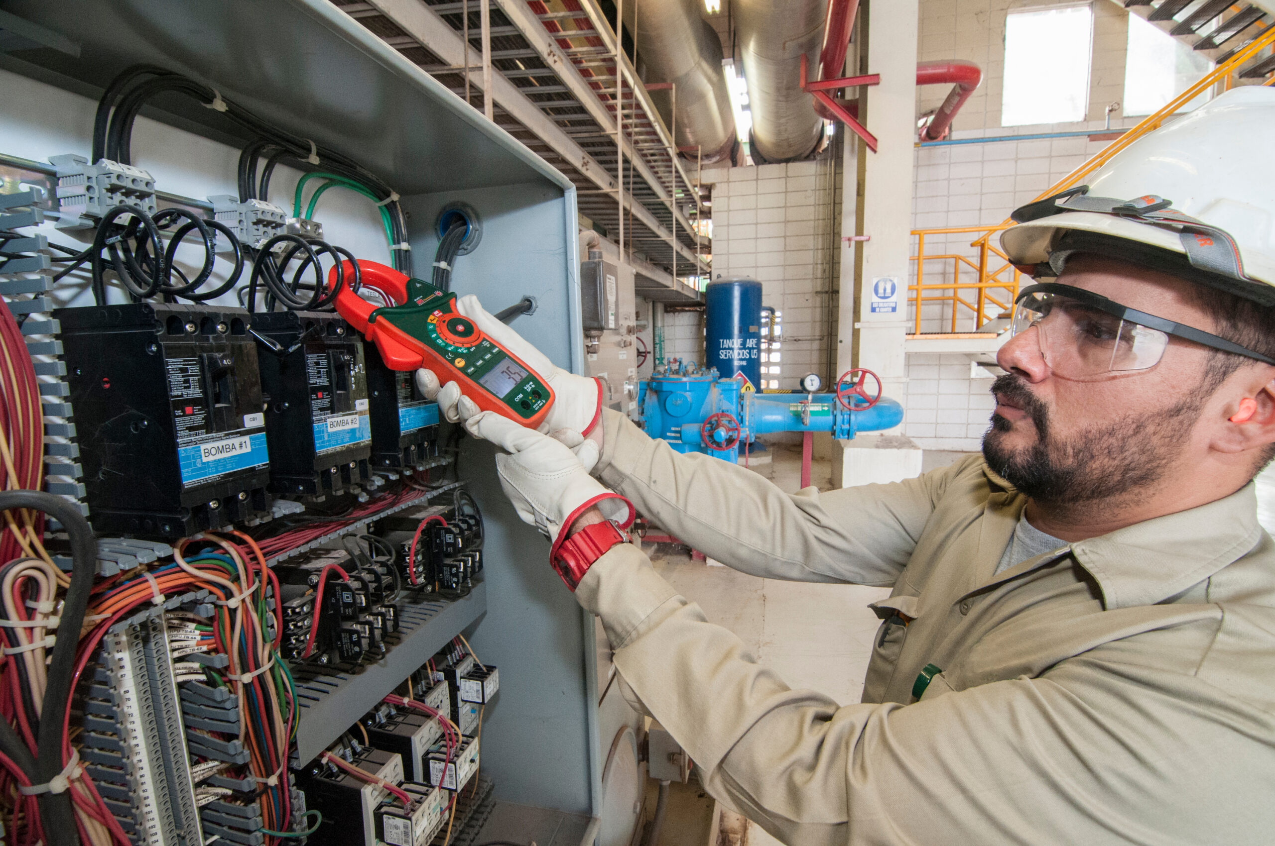 man working on an electrical circuit board in a factory.