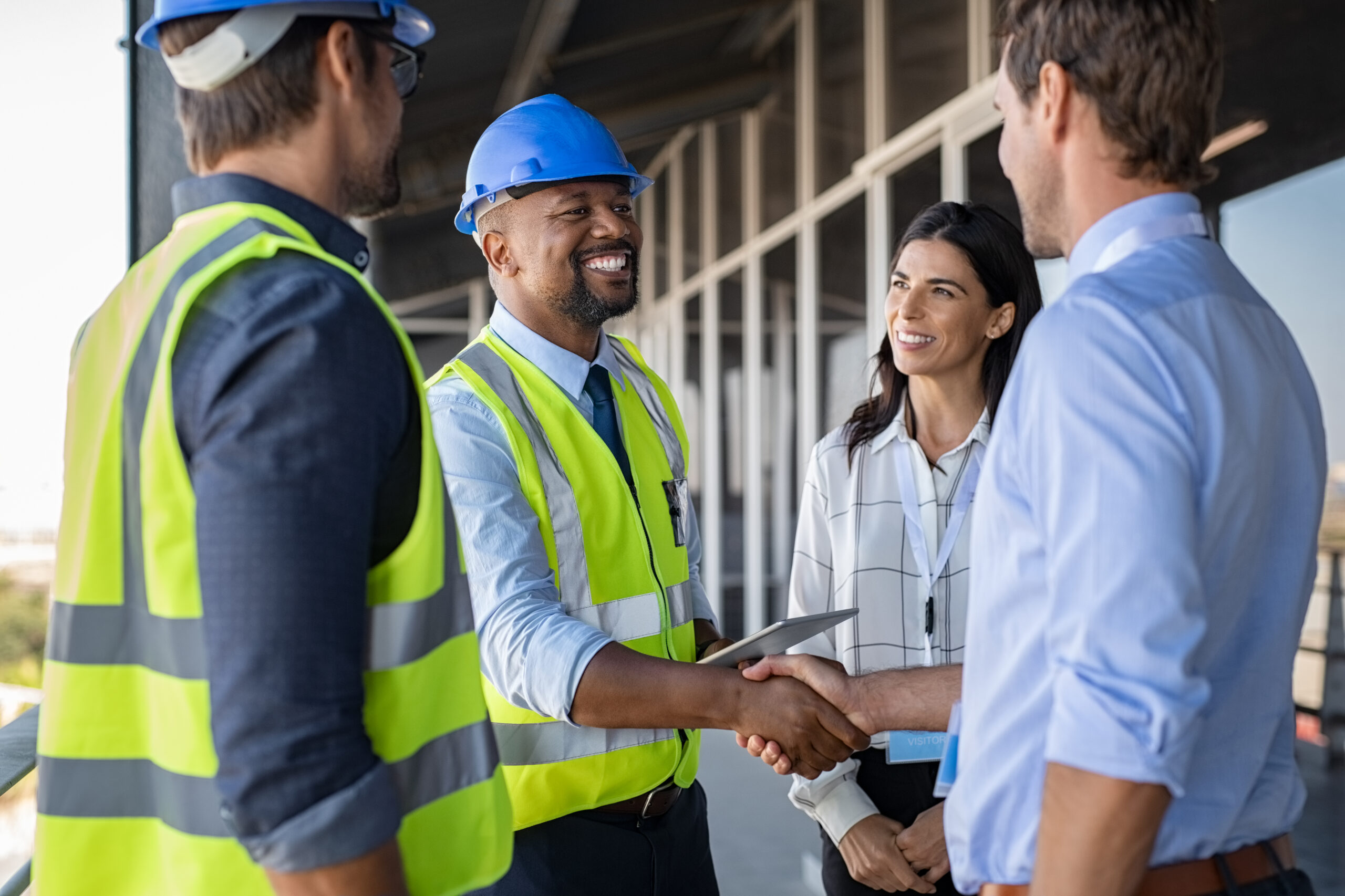 African American lead engineer shaking hands of colleagues at work.