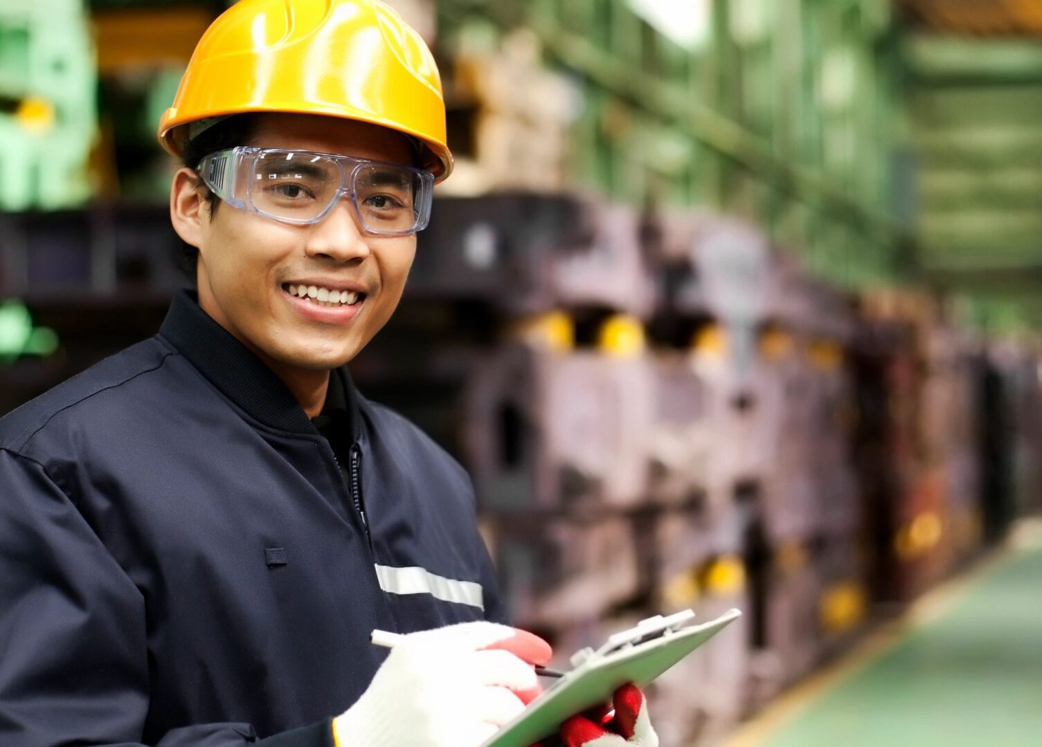 male engineer smiling in front of a chemical plant with a checklist on a clipboard