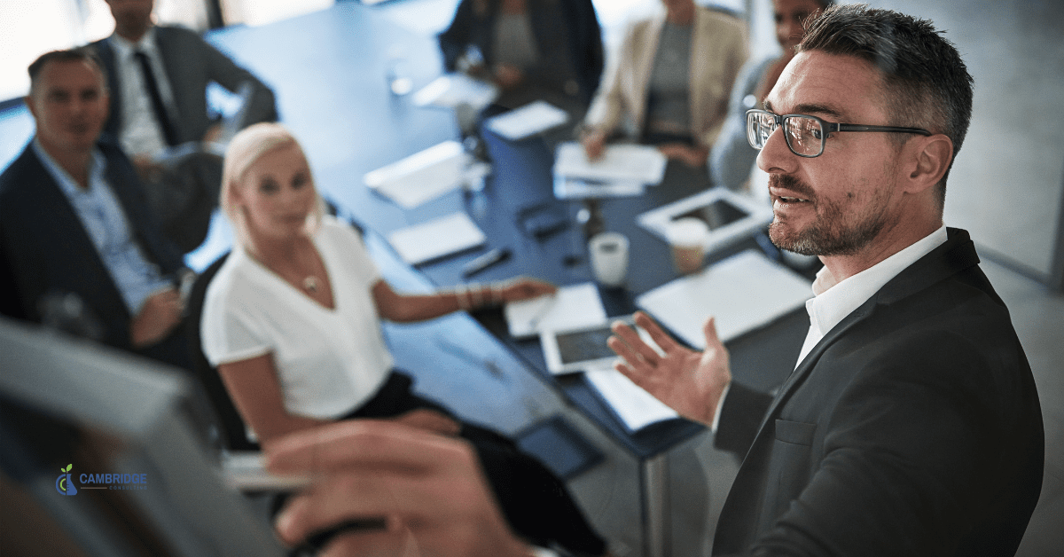 a businessman in a leadership position speaking to other corporate colleagues in a meeting