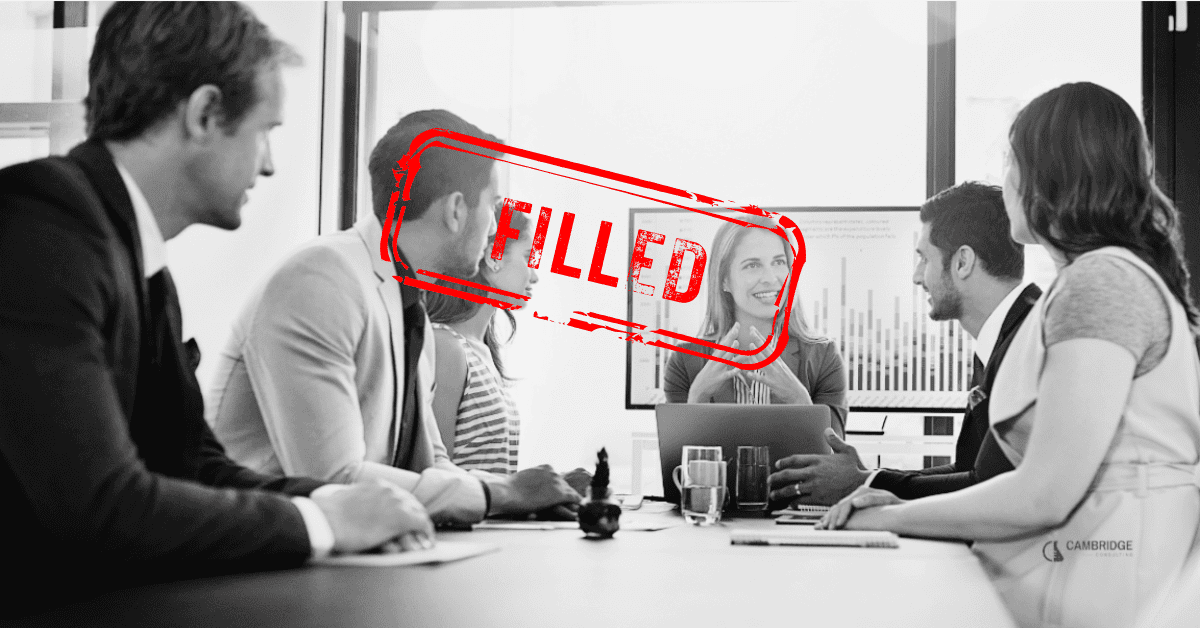 A black and white image of a group of professionals in a meeting with a stamp overlay that says "filled"