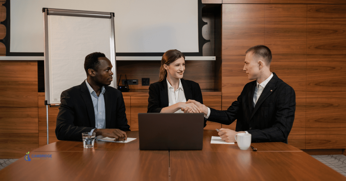 Three colleagues in a sales meeting with a deal being closed