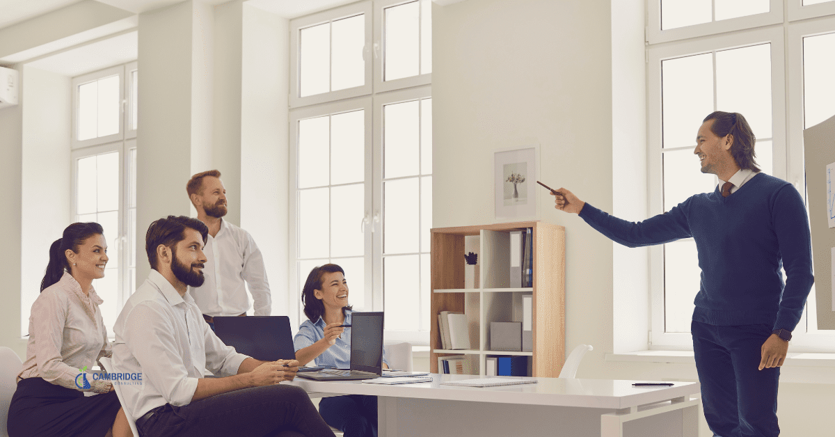 a sales leader speaking to his team in a corporate meeting room