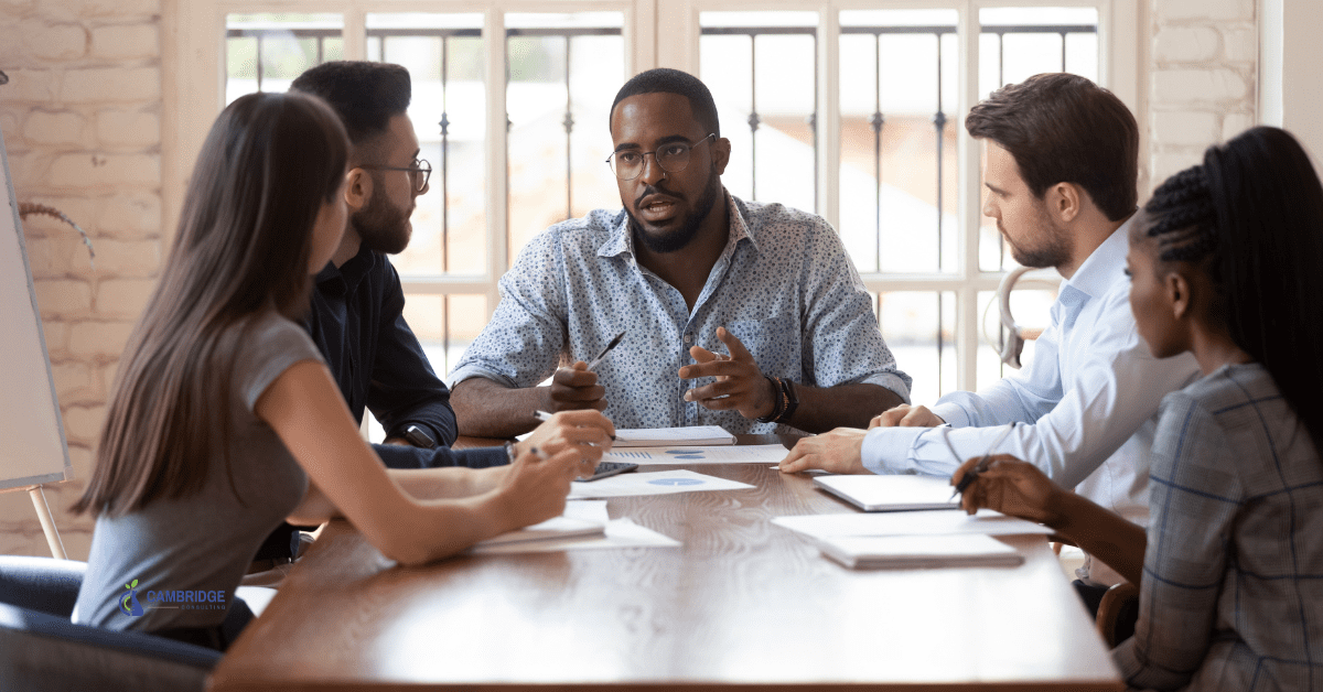 a team of corporate colleagues sitting around a conference table in a meeting