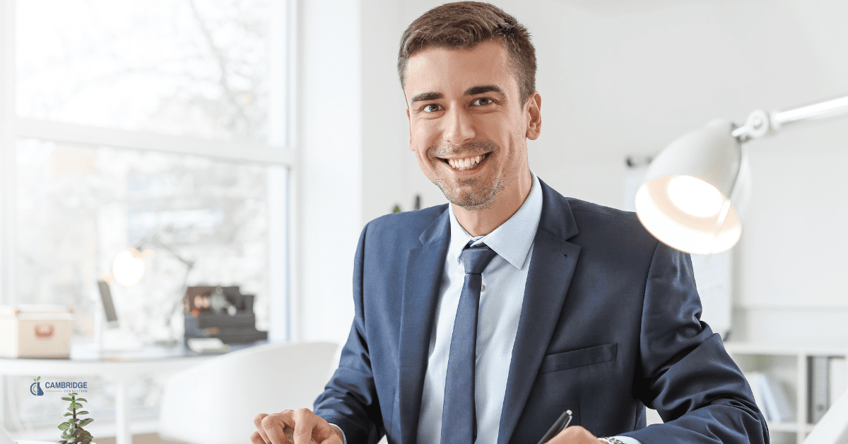 man smiling sitting down at a desk