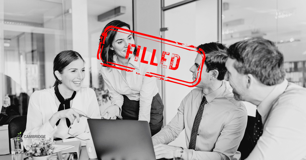 a black and white image of a corporate team meeting with a red stamp overlay that says "filled"