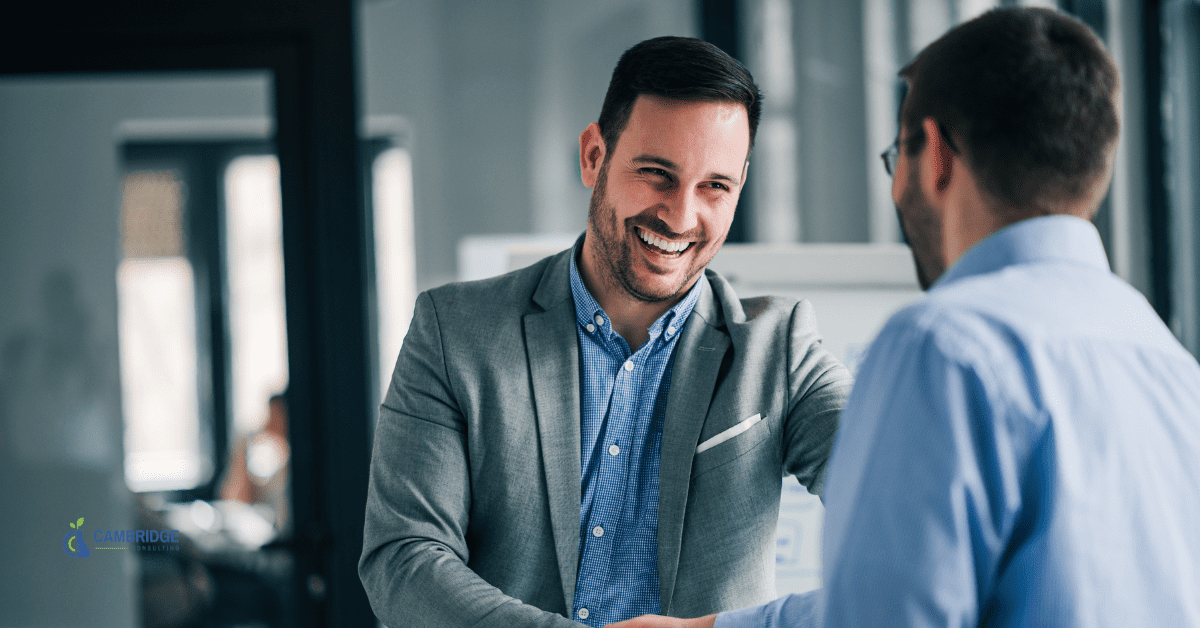 Account Manager 1800 two corporate men shaking hands in the office while laughing
