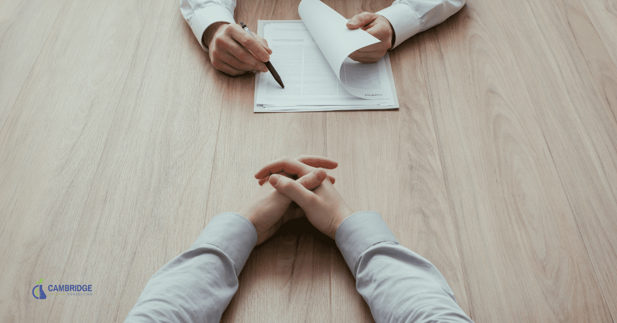 Mixed Messages in Interviews two men sitting opposite each other at a conference table during an interview