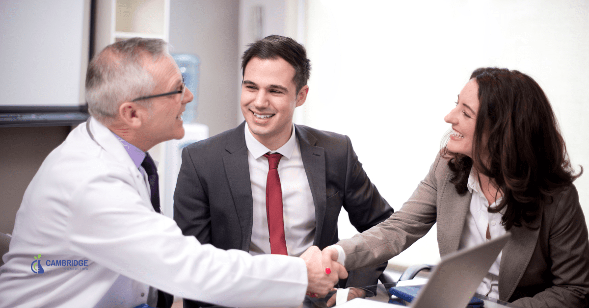 a team of colleagues shaking hands at the end of a sales meeting