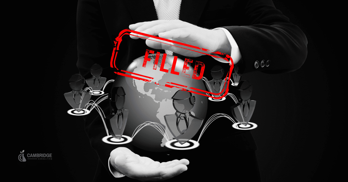 a black and white image of a hands over a globe with various touch points surrounding it with a red stamp overlay that says filled