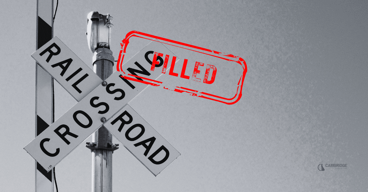 a black and white image of a railroad crossing sign with a red stamp overlay that says "filled"