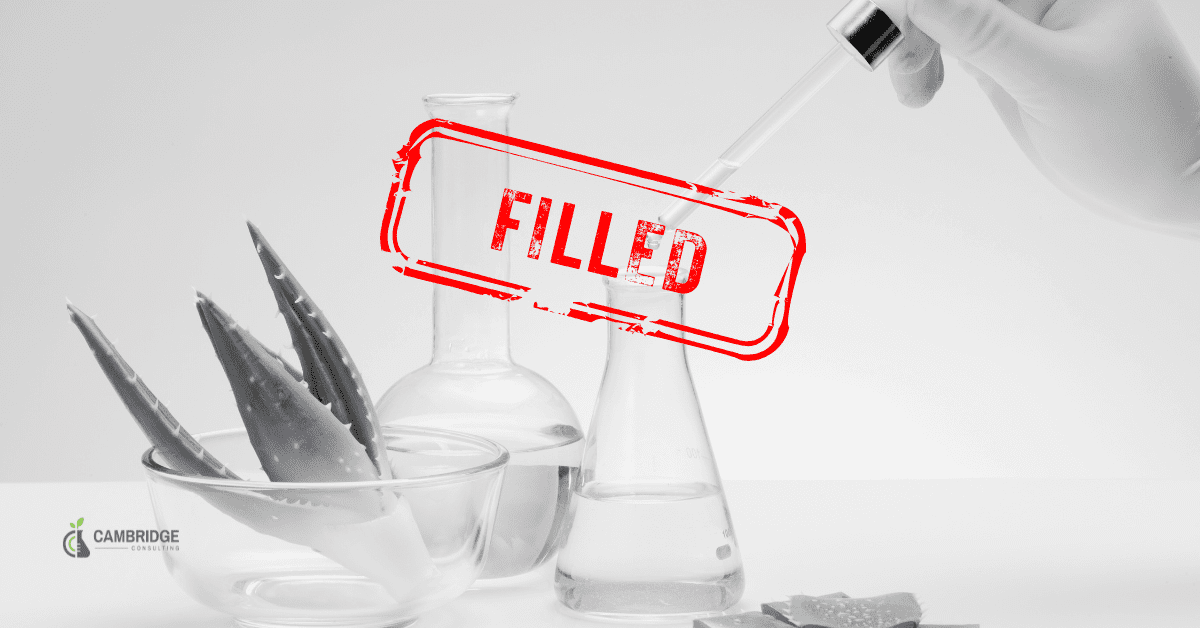 a black and white image of a scientist putting solutions into a beaker with a red stamp overlay that says FILLED