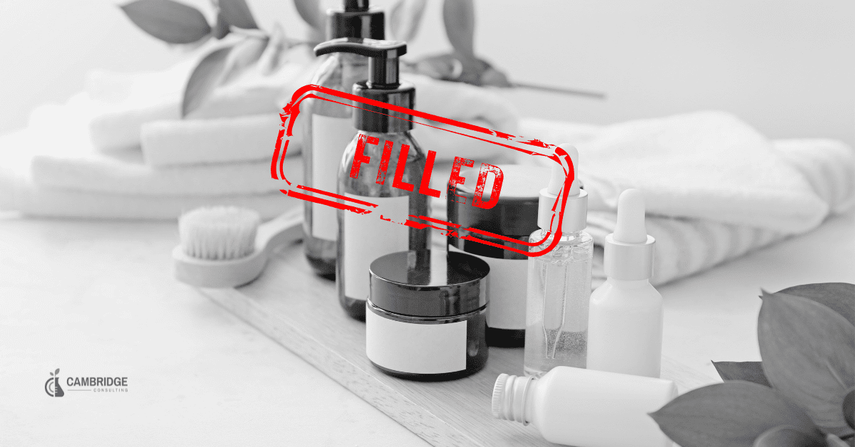 a black and white photo of personal care products with a red stamp overlay saying "FILLED" and the Cambridge Consulting Services logo in the bottom right corner