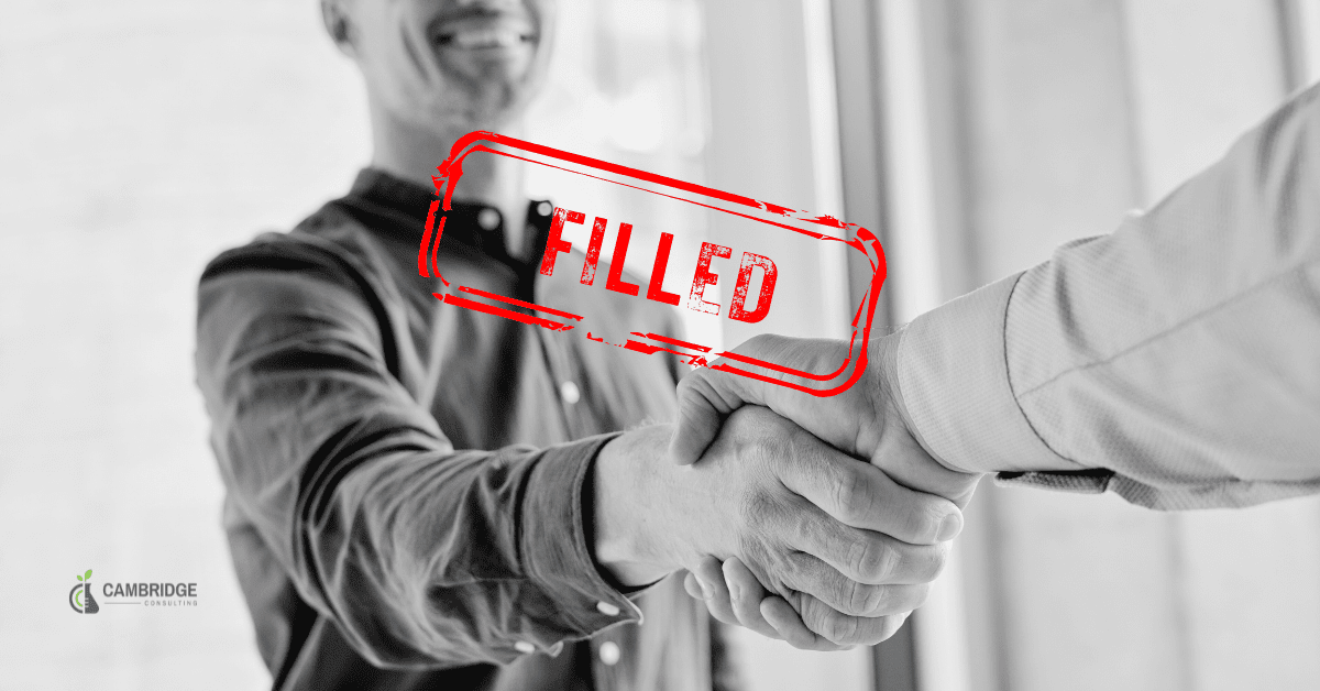 a black and white image of two businessmen shaking hands with a red text overlay that says filled