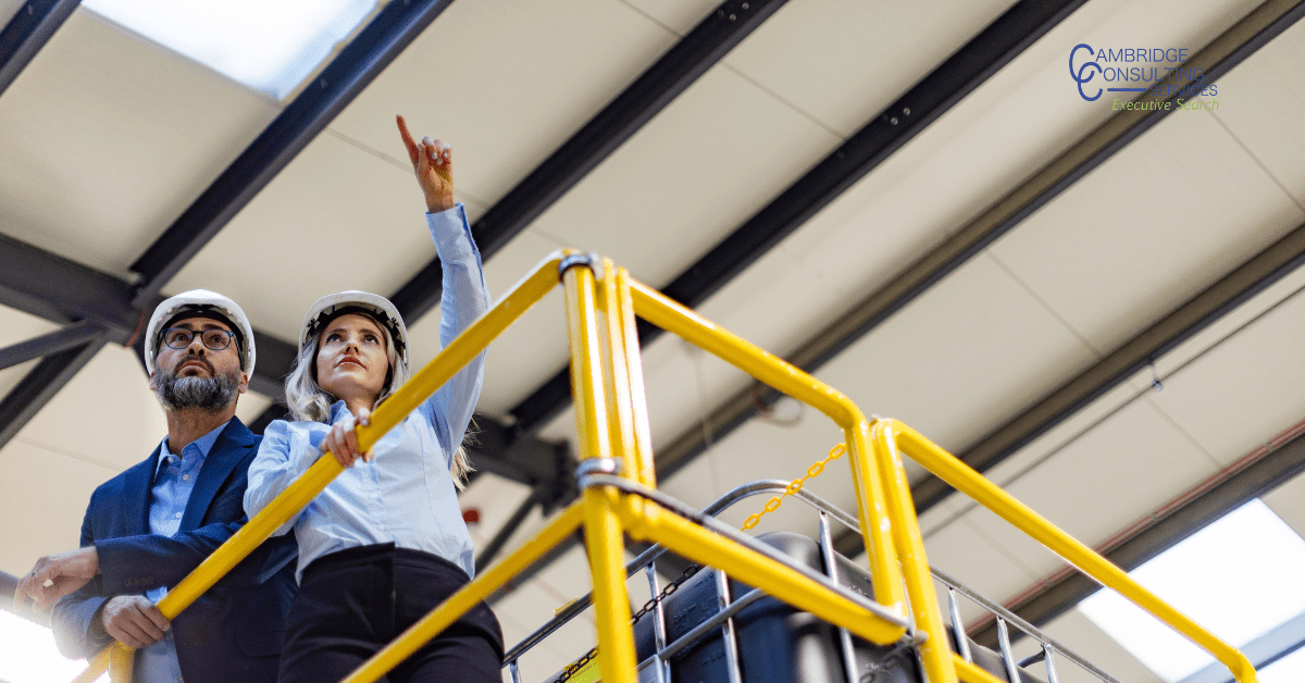 two manufacturing employees looking over the plant
