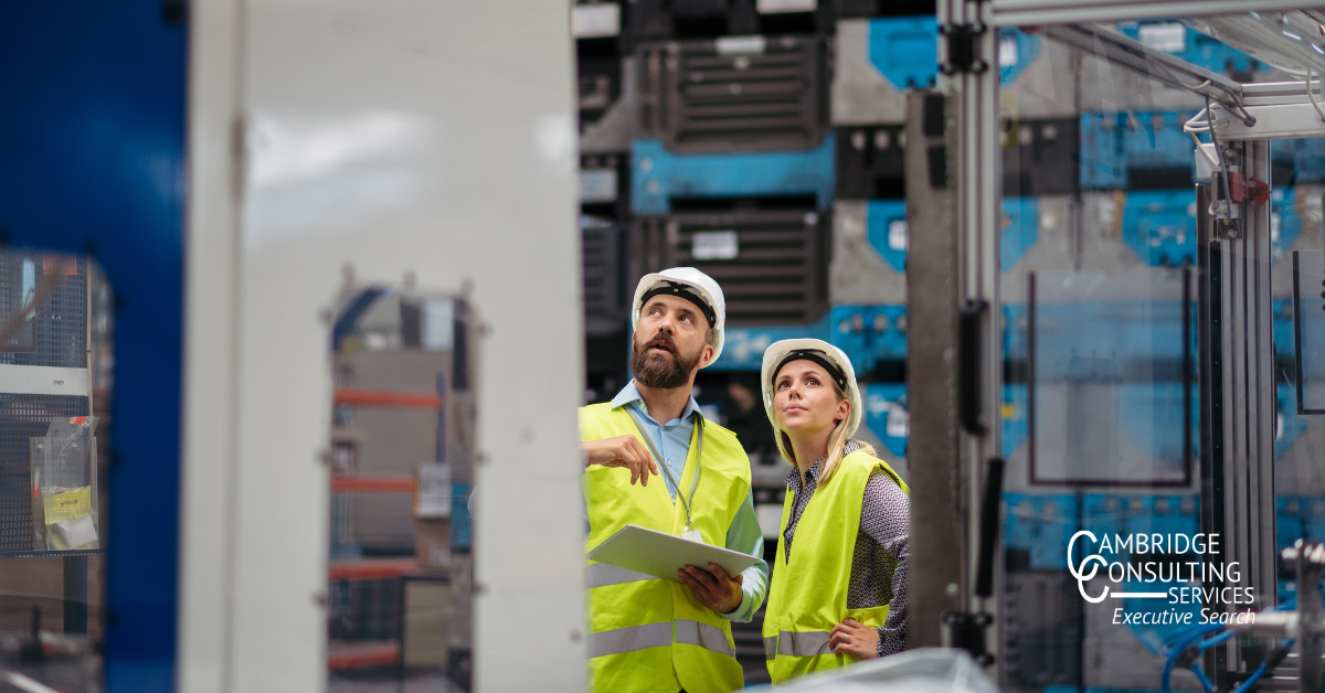 two plant managers overseeing a manufacturing facility with the Cambridge Consulting Services logo