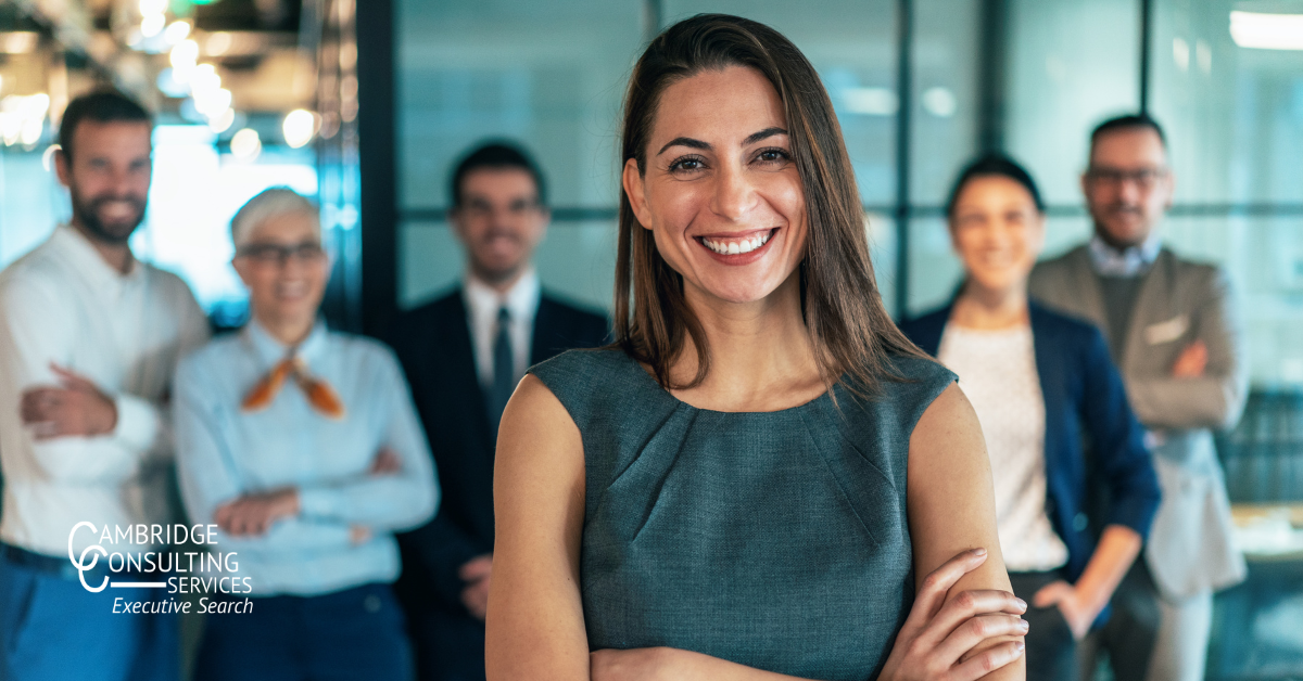 a sales leader standing in front of her team with the Cambridge Consulting Services logo in the bottom left corner